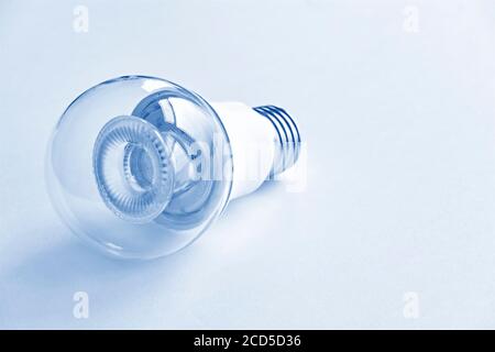 One transparent LED light bulb in monochrome blue. Energy saving concept. Stock Photo