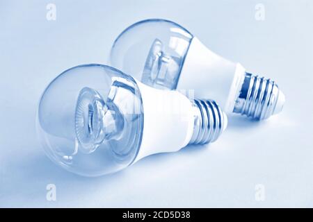 Two transparent LED light bulbs in monochrome blue. Energy saving concept. Stock Photo