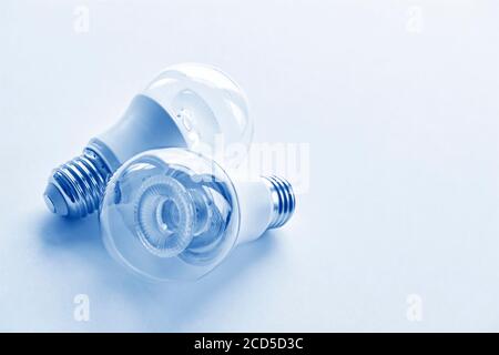 Two transparent LED light bulbs in monochrome blue. Energy saving concept. Image with copy space. Stock Photo