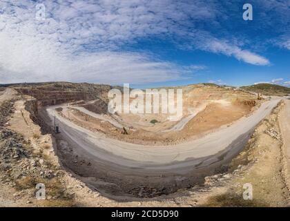 panorama over quarry, fluxes for the metal industry. Oval mining industrial crater, acid mine drainage in rock. Stock Photo