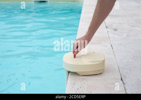 mans hand with contact key used to deactivate swimming pool alarm Stock Photo