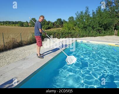 man cleaning a swimming pool with a net Stock Photo