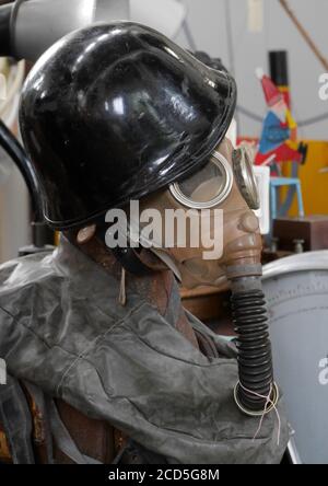 Antique War Time Gas Mask with breathing tube and air bag, along with Steel Helmet worn on a Mannequin Stock Photo