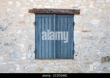 Closed window shutters in a stone wall Stock Photo