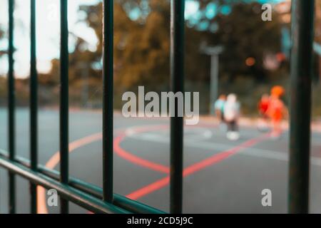 Soft focus of iron bars of a fence surrounding a basketball court at a park Stock Photo