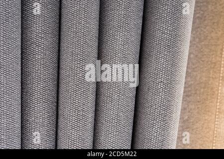 Closeup view of curtain in thin and thick vertical folds made of dense fabric.Textured materials and textiles abstract backgrounds. Stock Photo