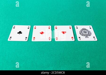 The four aces from a pack of cards lined up on a card table Stock Photo