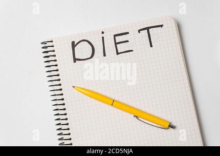 Title Diet on page of notepad and yellow pen. White background. Stock Photo