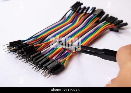 Multicolored computer wires and tweezers on a white background Stock Photo