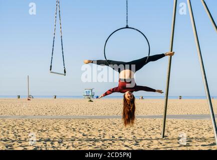 Female aerialist acrobat on beach near Santa Monica Pier, Santa Monica, California, USA Stock Photo