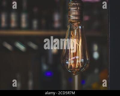 Transparent lamp with bright yellow orange wick on dark blurred background Stock Photo