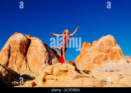 Woman on rock formation, Aztec Sandstone,  State Park, Mohave Desert, Overton, Nevada, USA Stock Photo