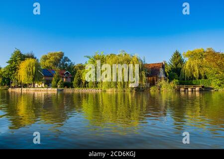 Log cabins and cottages among trees on the lake in Varazdin, rural Croatia Stock Photo