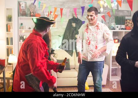 Man dressed up like a scary zombie covered in blood at halloween celebration. Stock Photo
