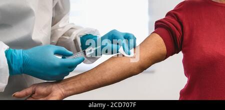 Doctor doing medical injection syringe vaccine to senior patient in hospital for preventing and stop corona virus outbreak Stock Photo