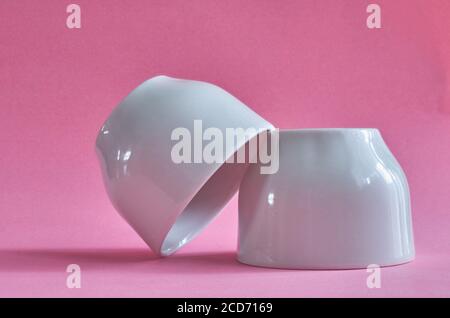 Two white ceramic cups without handles on a pink background Stock Photo