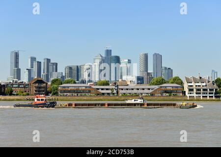 Thames river tug and Canary Wharf docklands, Greenwich, London, United Kingdom Stock Photo