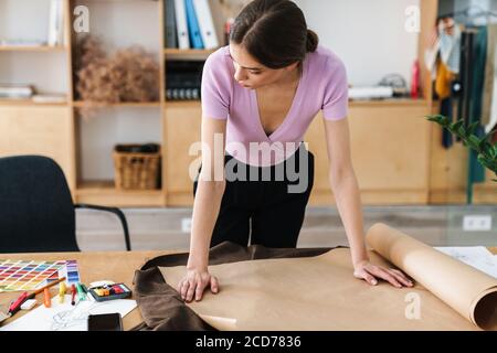 Image of concentrated woman designer indoors in office working on project Stock Photo