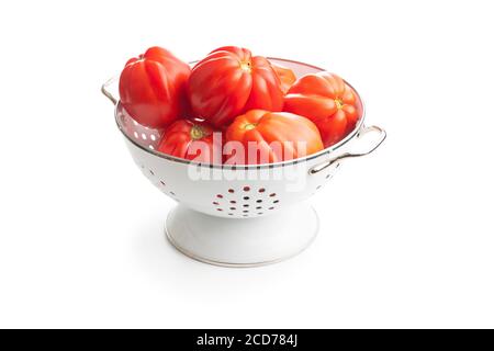 Red beefsteak tomatoes in colander isolated on white backround. Stock Photo