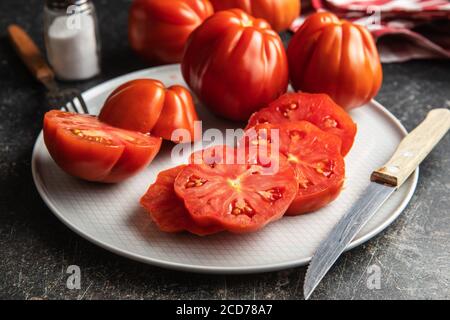 Red beefsteak tomatoes on plate. Stock Photo