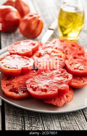 Sliced red beefsteak tomatoes on plate. Stock Photo