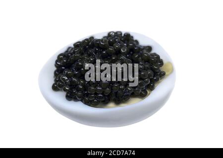 Black caviar on boiled egg isolated on white Stock Photo