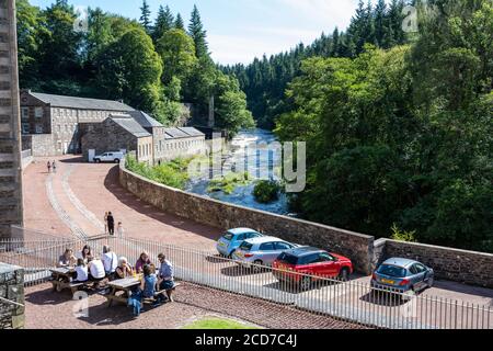 Visitors enjoying the summer sunshine at New Lanark World Heritage Site, New Lanark, Lanarkshire, Scotland, UK Stock Photo