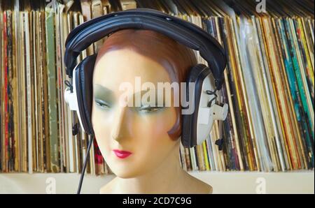 vintage display dummy, mannequin wearing professionell headphones vinyl records in the background, retro analog music concept Stock Photo