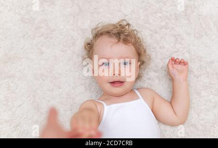 Portrait of a little girl who lies on the carpet Stock Photo