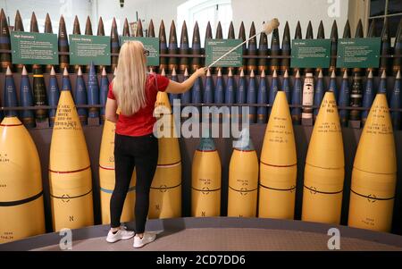 A member of staff at Explosion Museum of Naval Firepower in Gosport, part of the National Musuem of the Royal Navy, cleans a display of different shells, as final preparations are made prior to the re-opening of the museum on Saturday. Stock Photo