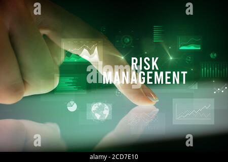 Finger touching tablet with charts and RISK MANAGEMENT inscription, business concept Stock Photo