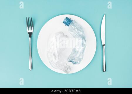 Plate with plastic bottles on blue background.