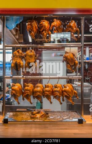 Roasted ducks and chickens hanging on shopping window, rack showcase in restaurant's kitchen Stock Photo