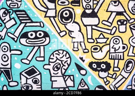 Brick wall painted with the graffiti characters on the colorful background. Stock Photo