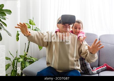 Senior man wearing virtual reality goggles at home Stock Photo