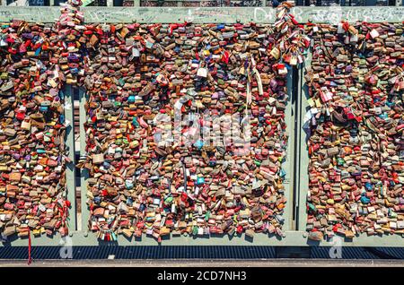 Cologne, Germany, August 23, 2019: many love locks padlocks on railing of Hohenzollern steel bridge or Hohenzollernbrucke across Rhine river, symbol of love Stock Photo