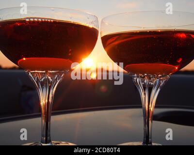 A Pair of champagne glasses filled with rose' at sunset Stock Photo