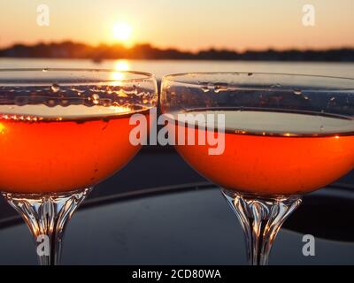 A Pair of champagne glasses filled with rose' at sunset Stock Photo