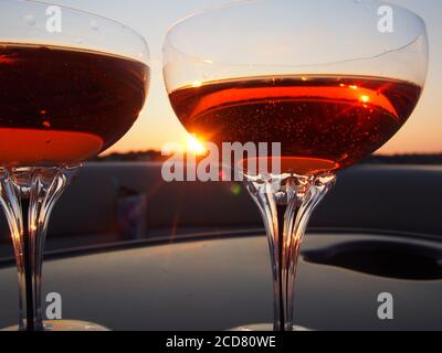 A Pair of champagne glasses filled with rose' at sunset Stock Photo