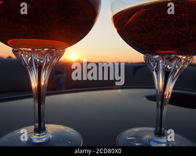 A Pair of champagne glasses filled with rose' at sunset Stock Photo