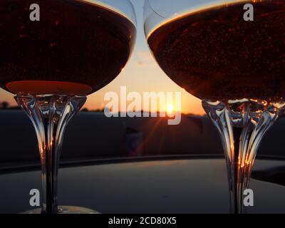 A Pair of champagne glasses filled with rose' at sunset Stock Photo