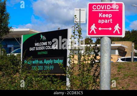 A sign for East Sussex College, Hastings campus, next to a 'Covid 19 keep apart sign' in Hastings, Sussex, England, UK. Stock Photo
