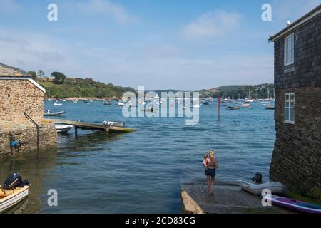 Mother and young child standing on the slipway at Market Street overlooking the boats on the Salcombe Estuary in Salcombe, South Hams,Devon Stock Photo