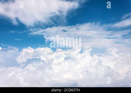Panoramic view of fluffy cumulus thunderclouds and cirrus on a summer day from the height of the plane Stock Photo