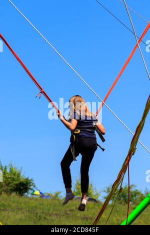 Girl jumping on bungee trampoline Stock Photo