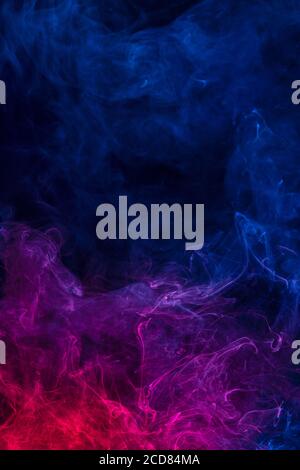 Conceptual image of multi-colored smoke isolated on dark black background, Halloween design element. Stock Photo