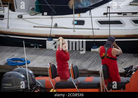 Two lifeguards cast off in a ribcraft in Brighton Marina, East Sussex Stock Photo