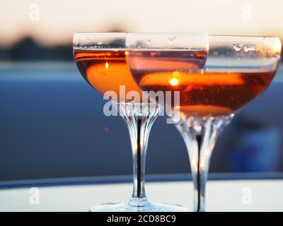 A Pair of champagne glasses filled with rose' at sunset Stock Photo