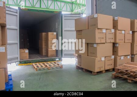 loading shipment carton boxes and goods on wooden pallet at loading dock from container Stock Photo