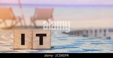 IT letters on Wooden Cubes on swimming pool borders. business concept Stock Photo